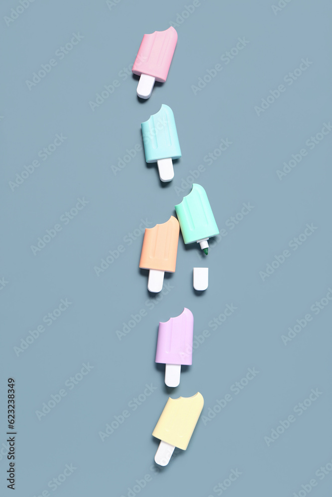 Colorful markers in shape of ice cream on grey background