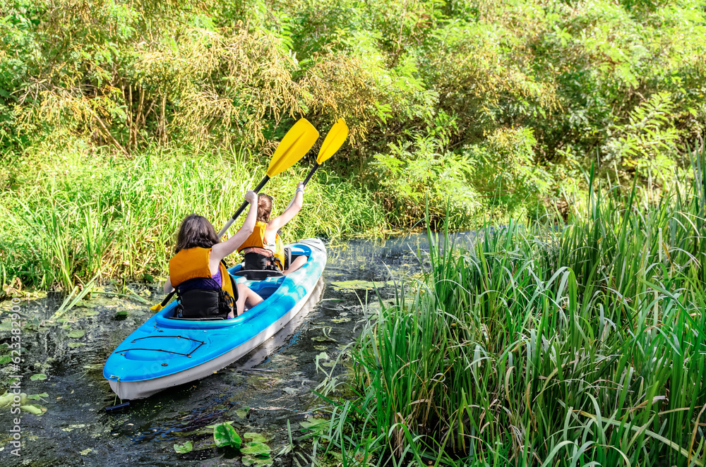 Family kayaking, mother and child paddling in kayak on river canoe tour, active summer weekend and v