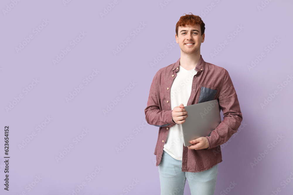 Male programmer with laptop on lilac background