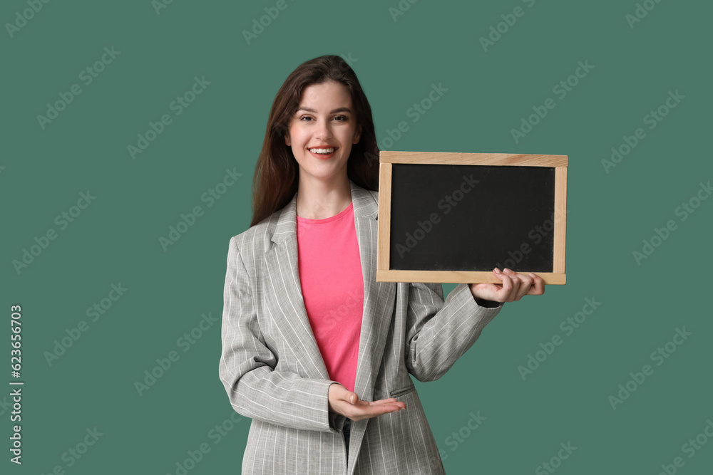 Female teacher with chalkboard on green background