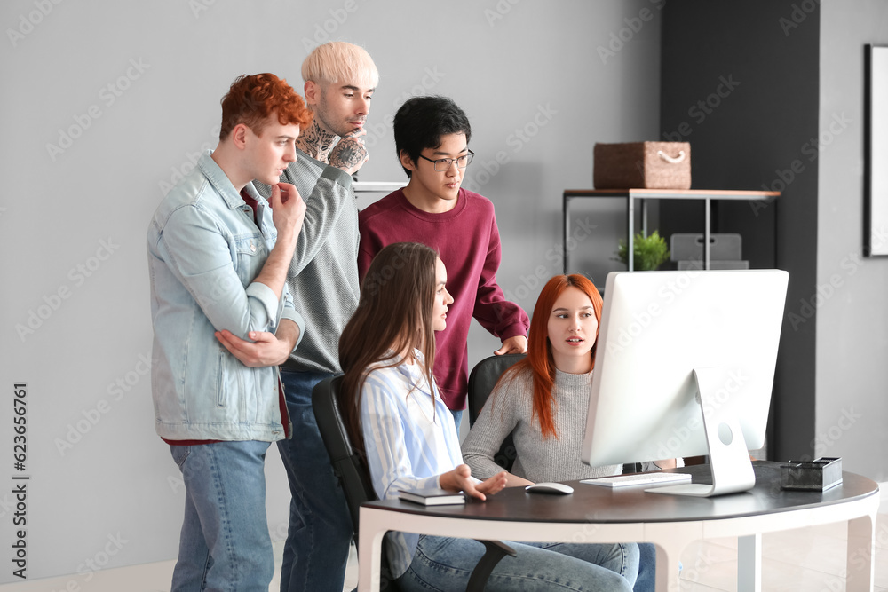 Team of young programmers working with computer in office