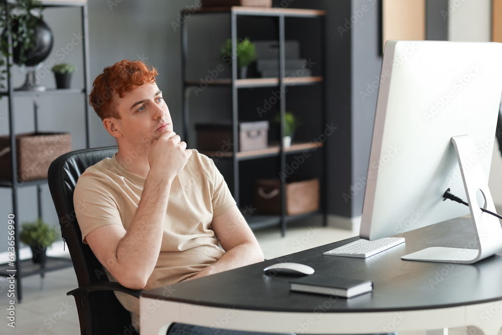 Thoughtful male programmer working in office