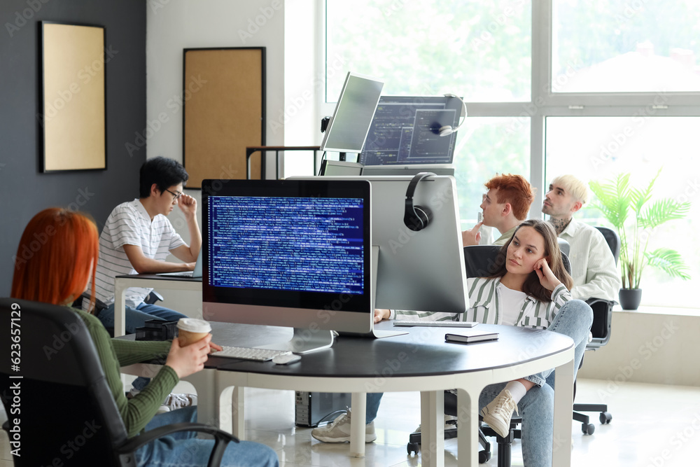 Team of young programmers working in office