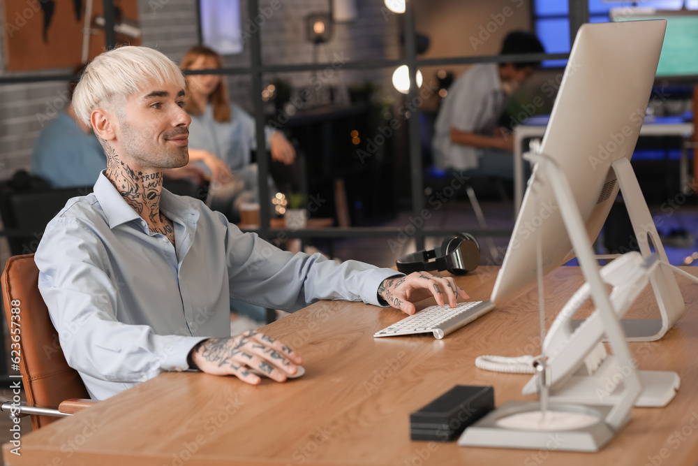 Male programmer working with computer in office at night