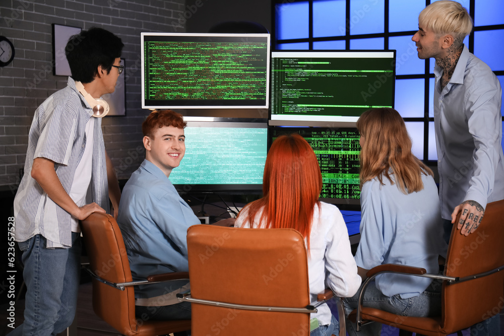 Team of young programmers working in office at night