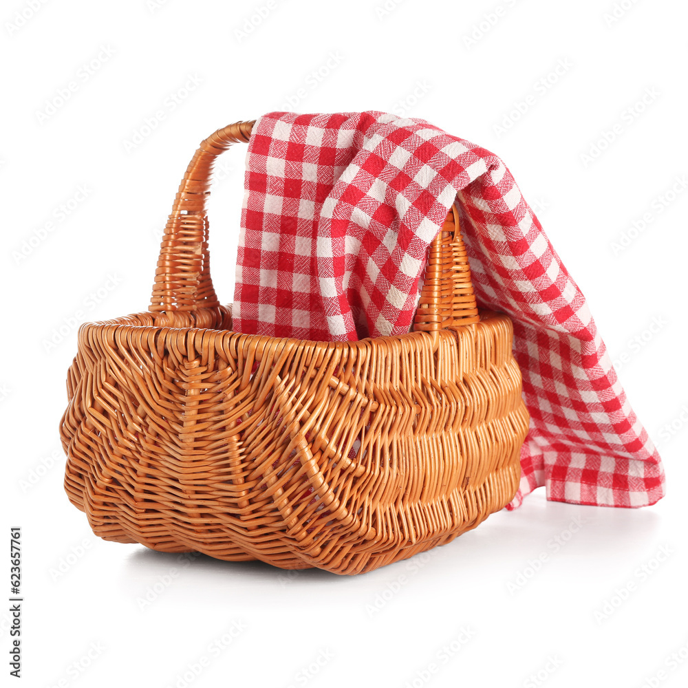 Wicker picnic basket with red checkered napkin isolated on white background