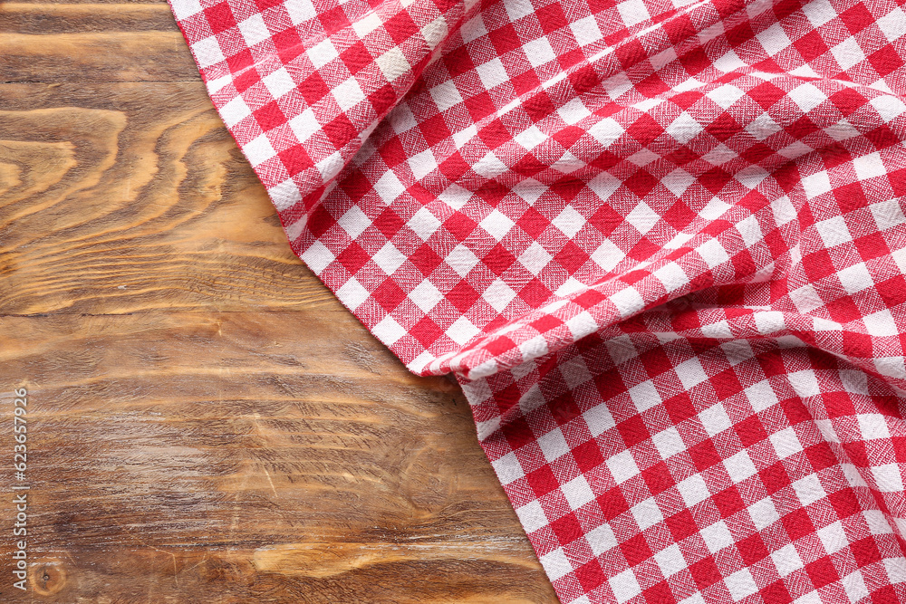 Red checkered napkin on wooden background