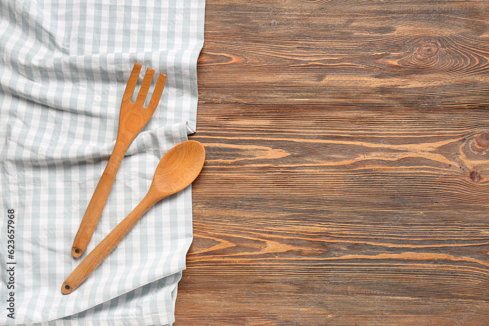 Clean napkin, spoon and fork on wooden background