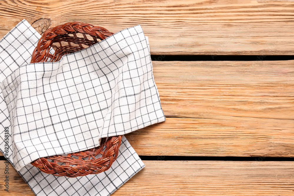 Wicker basket with clean napkins on wooden background