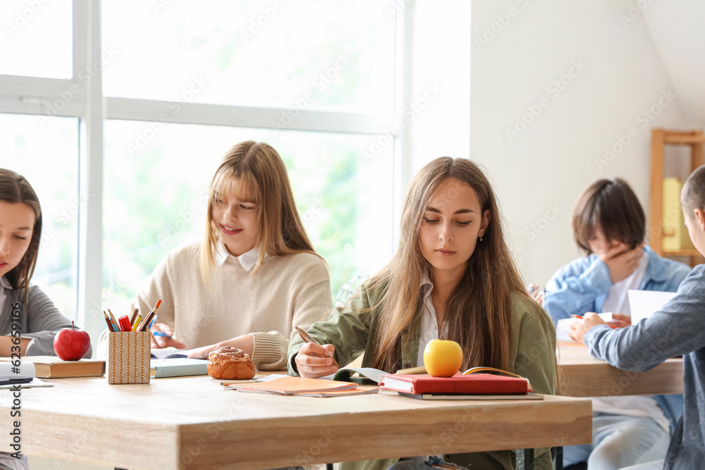 Group of teenage students studying in classroom