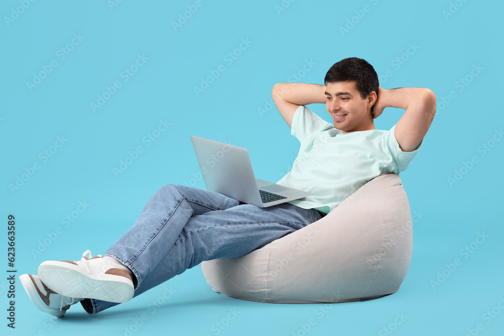 Male programmer working with laptop on blue background