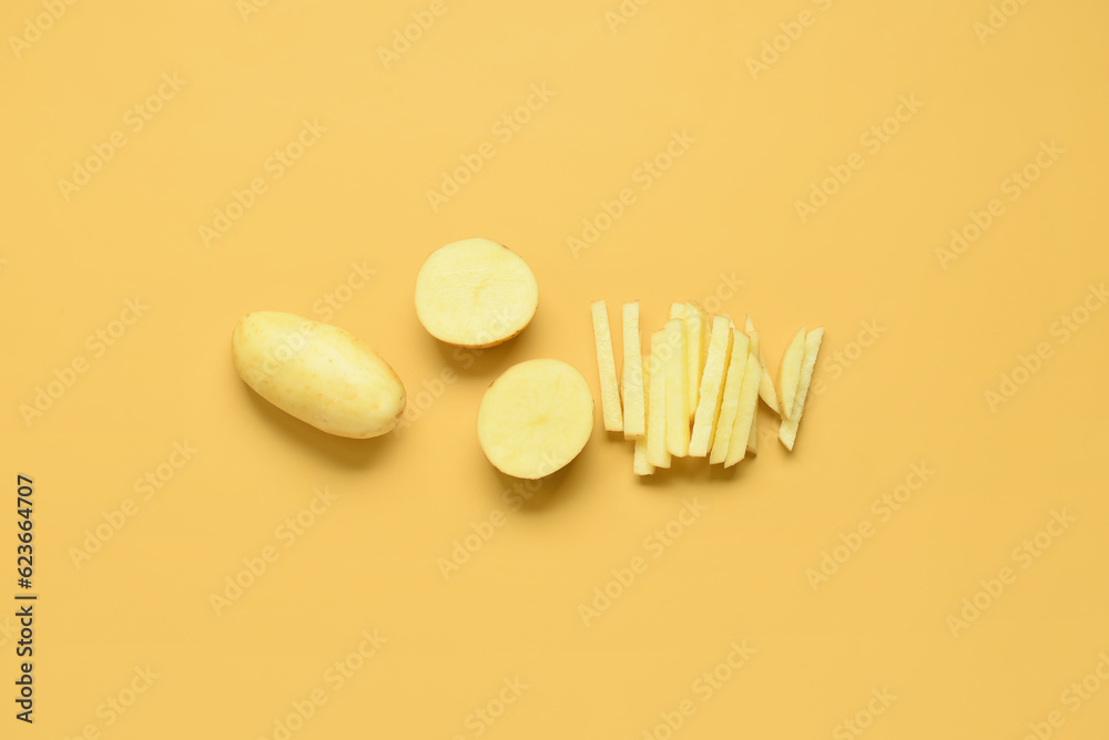 Whole and cut potatoes on yellow background