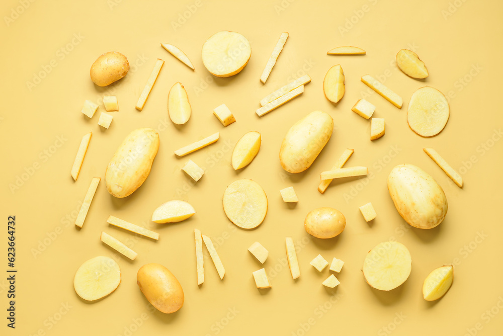 Whole and cut potatoes on yellow background