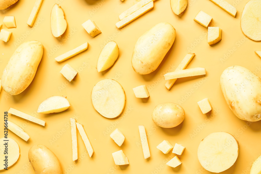 Whole and cut potatoes on yellow background