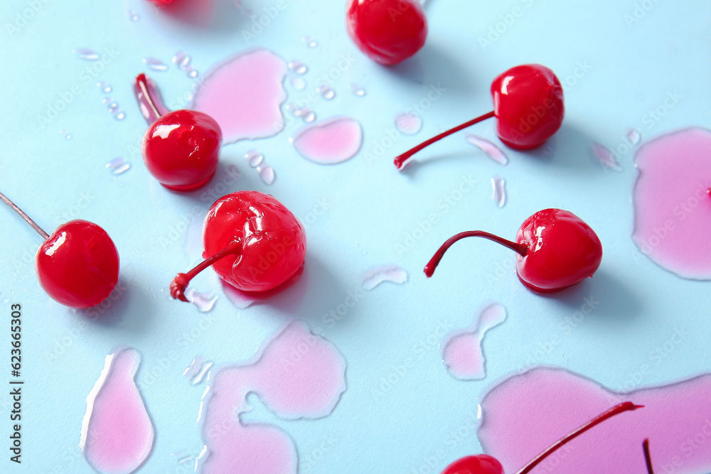 Tasty maraschino cherries on blue background