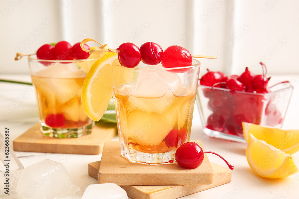 Glasses of tasty cocktail with maraschino cherries on table