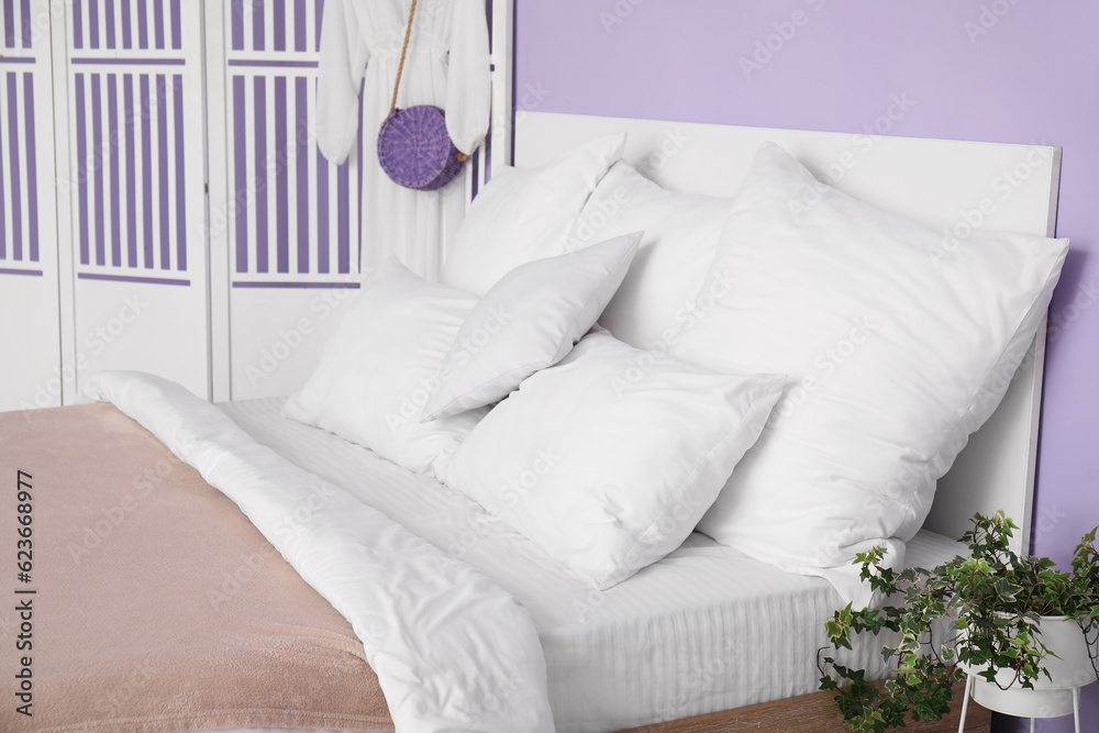 White pillows on bed in stylish bedroom