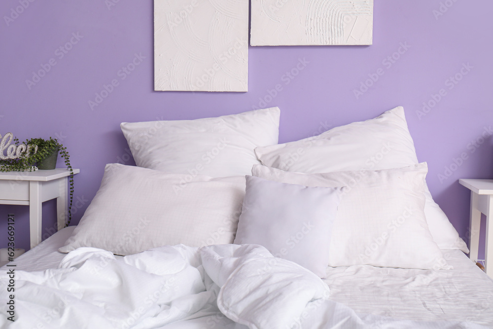 Comfortable bed with white pillows in interior of stylish bedroom