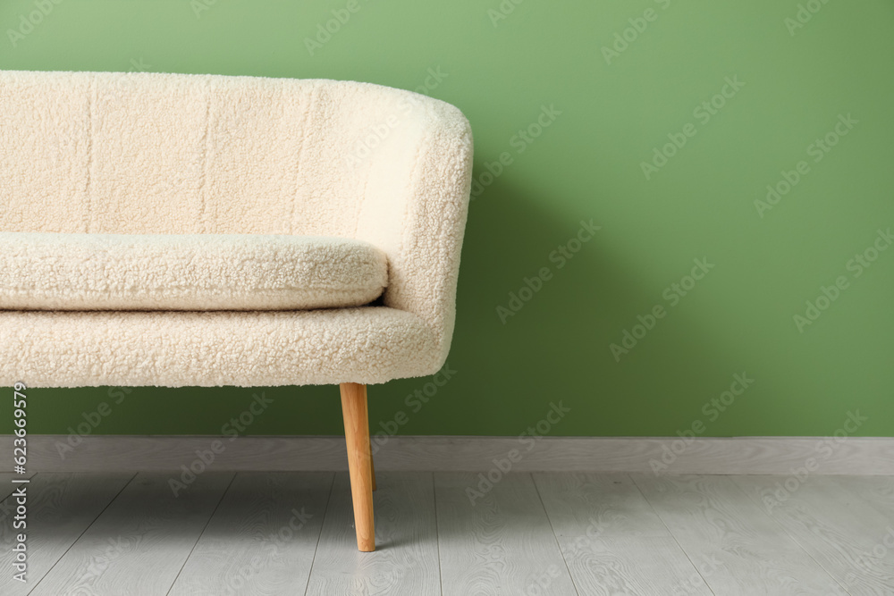 Cozy white sofa near green wall