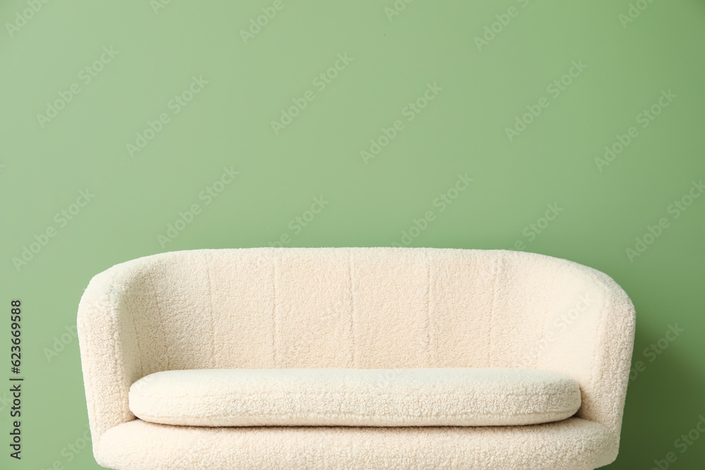 Cozy white sofa near green wall