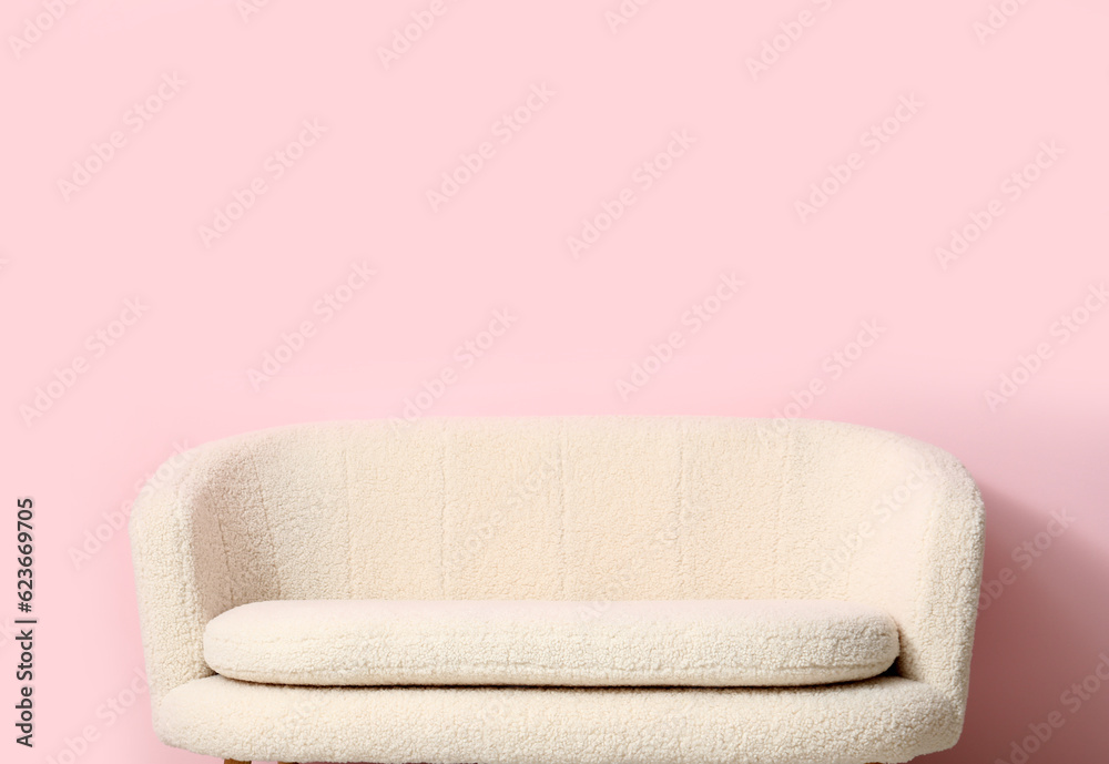 Cozy white sofa near pink wall