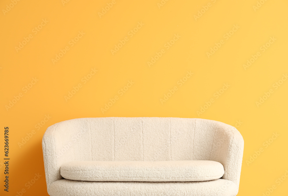 Cozy white sofa near orange wall