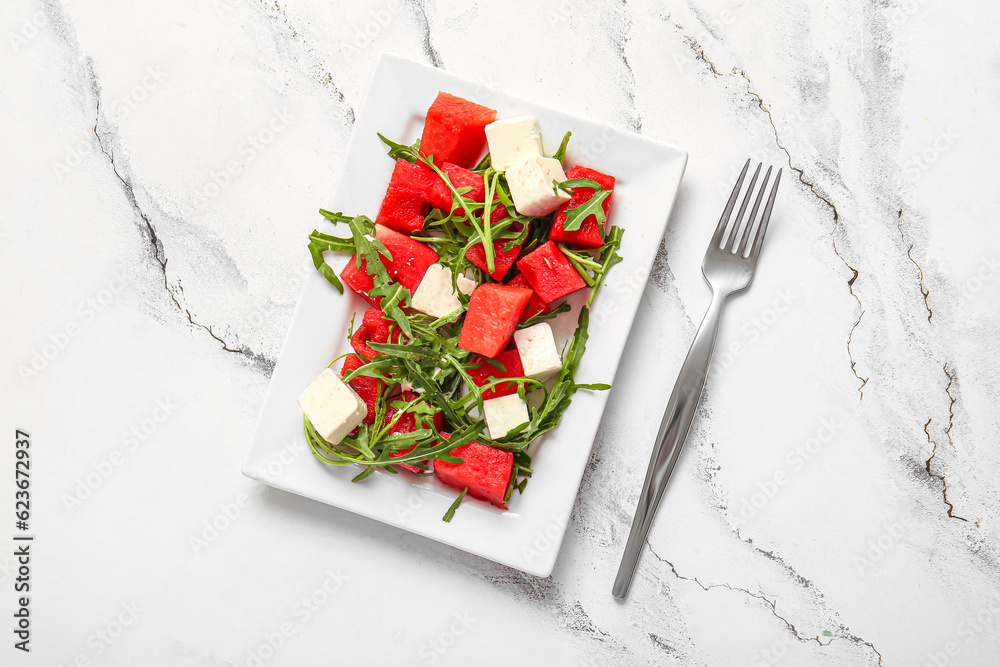 Plate of tasty watermelon salad on white marble background