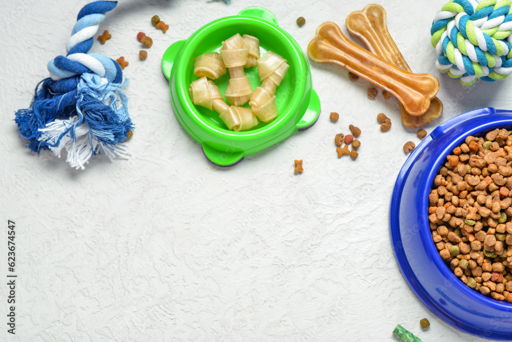 Composition with different dog food and toys on light background