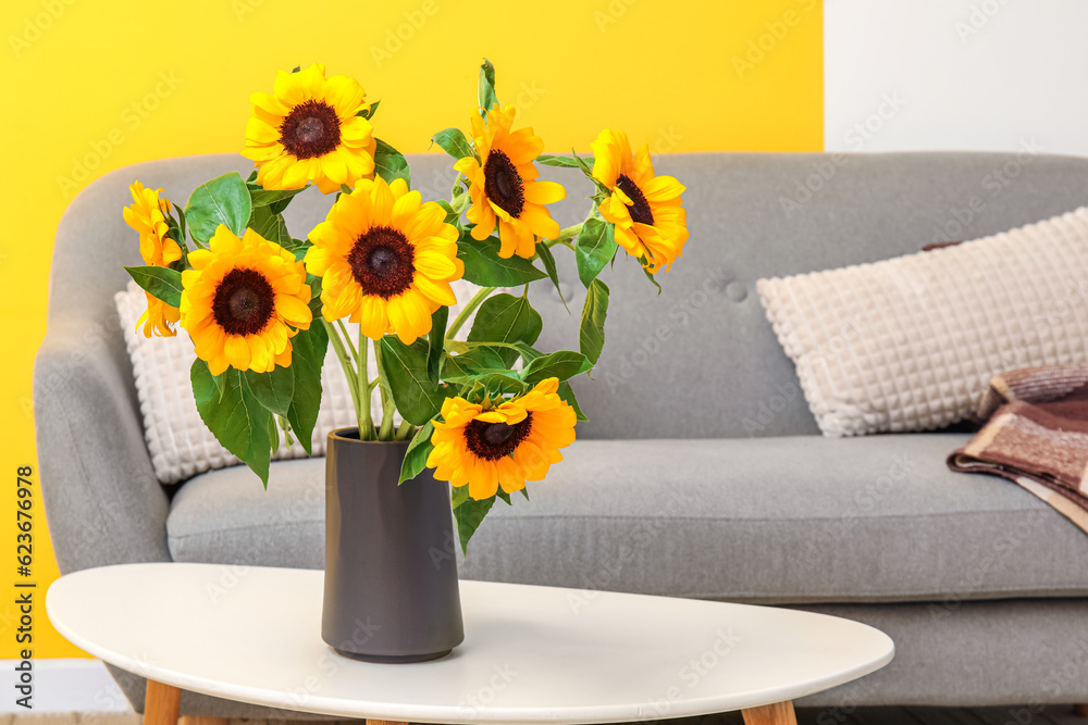 Vase with sunflowers on table in living room