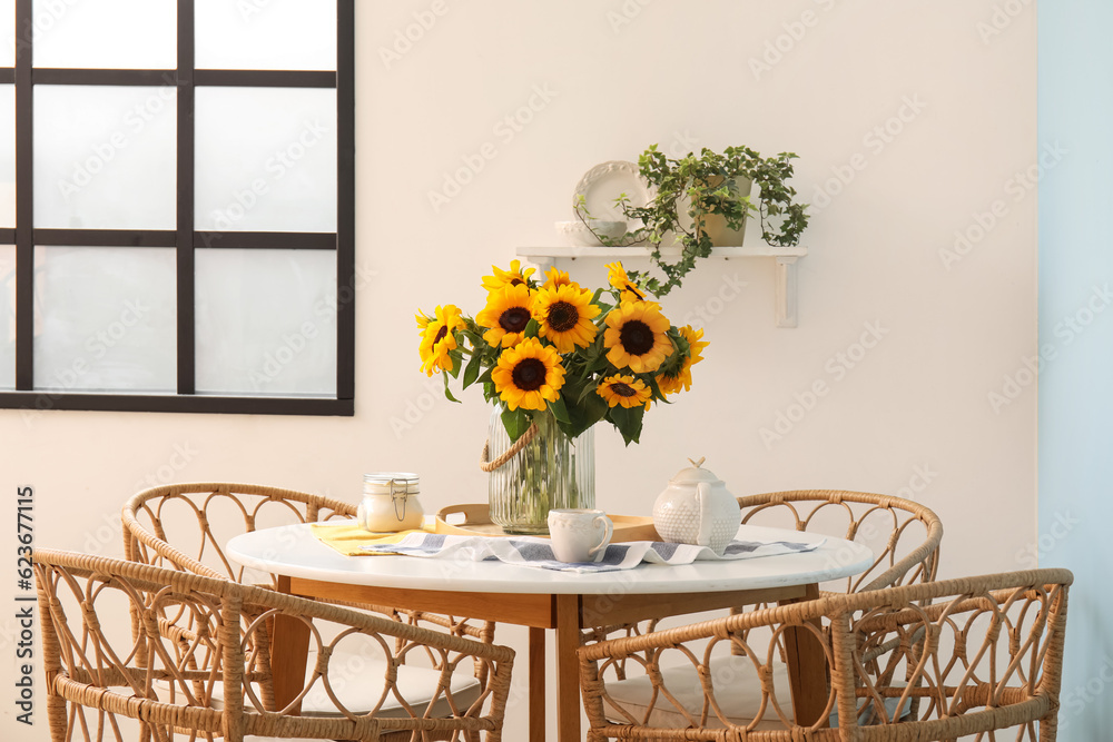 Vase with beautiful sunflowers on dining table