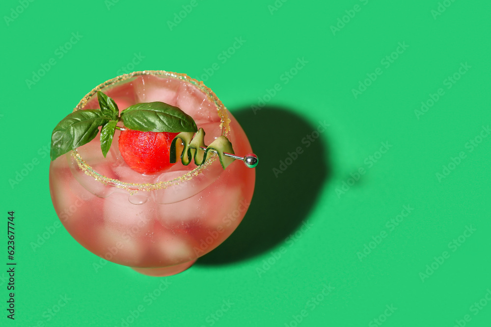 Glass of tasty watermelon cocktail on green background