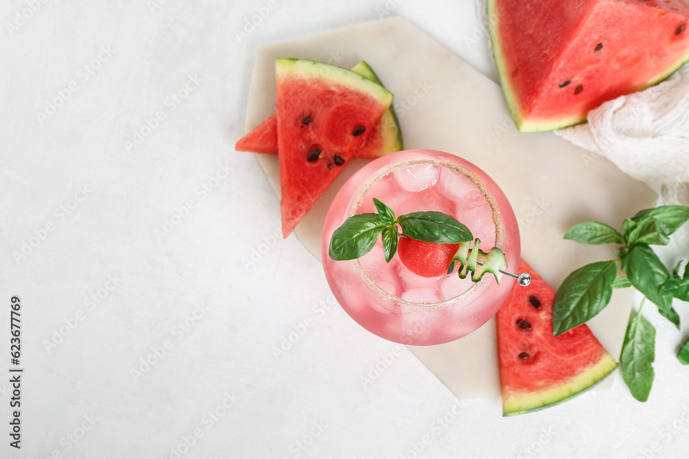 Board with glass of tasty watermelon cocktail and mint on white background