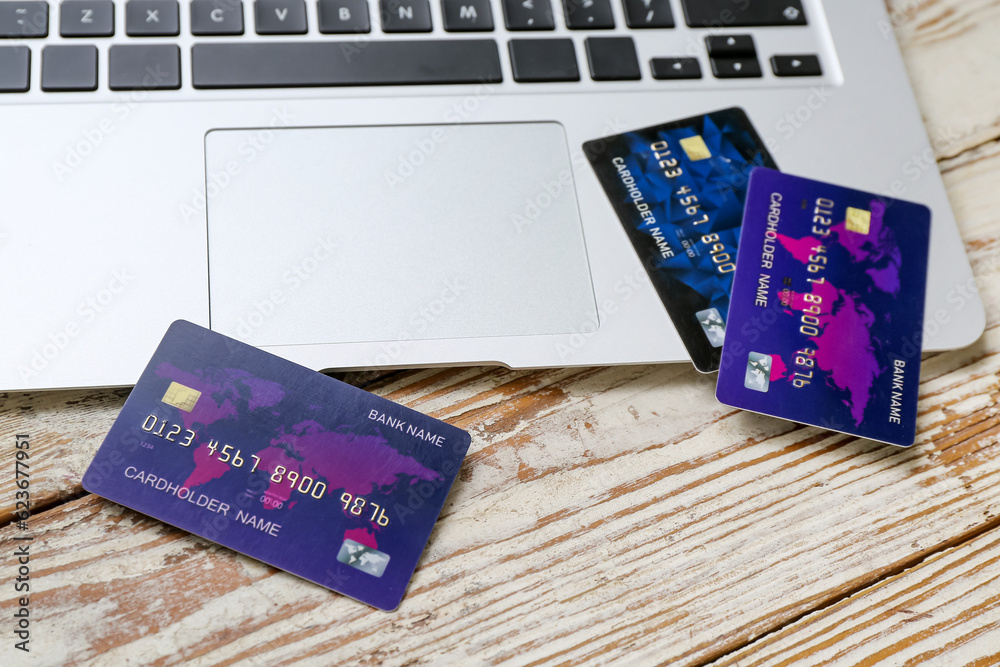 Laptop with credit cards on light wooden background