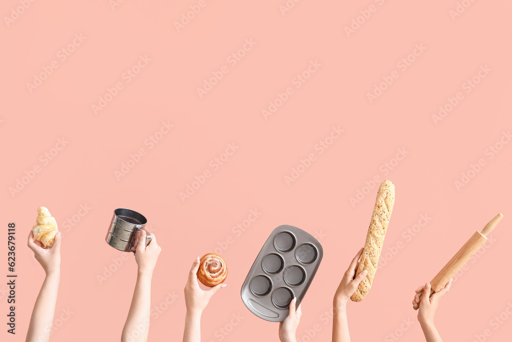 Female hands with baking utensils and pastry on pink background