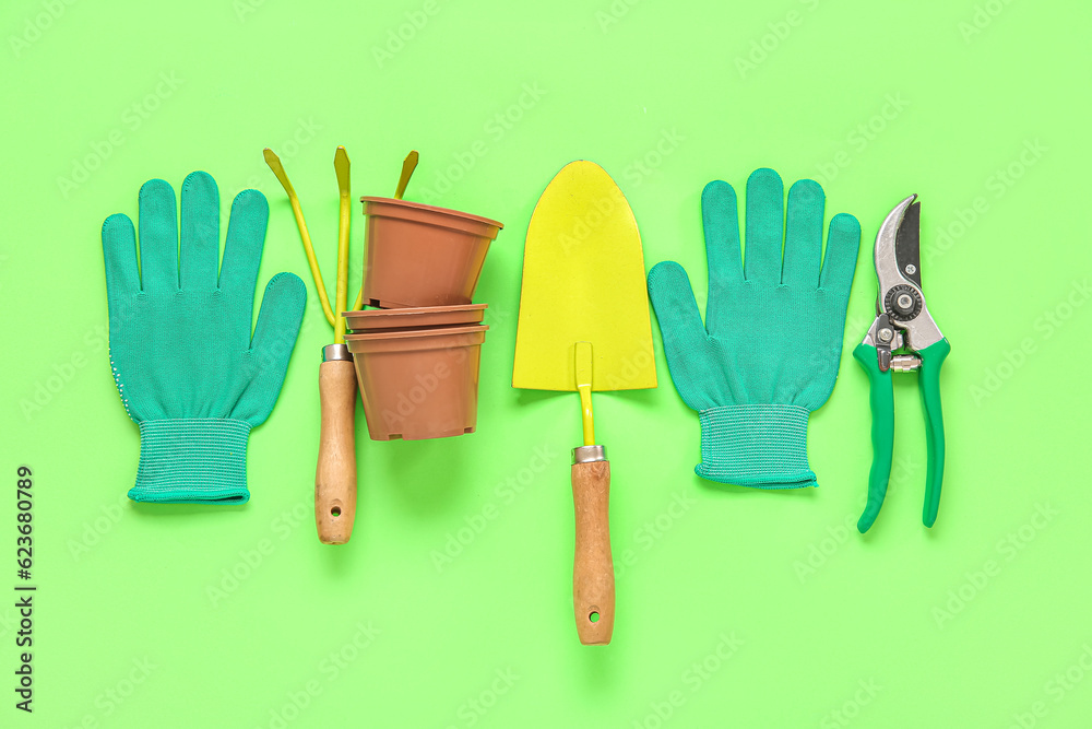 Different gardening tools on green background