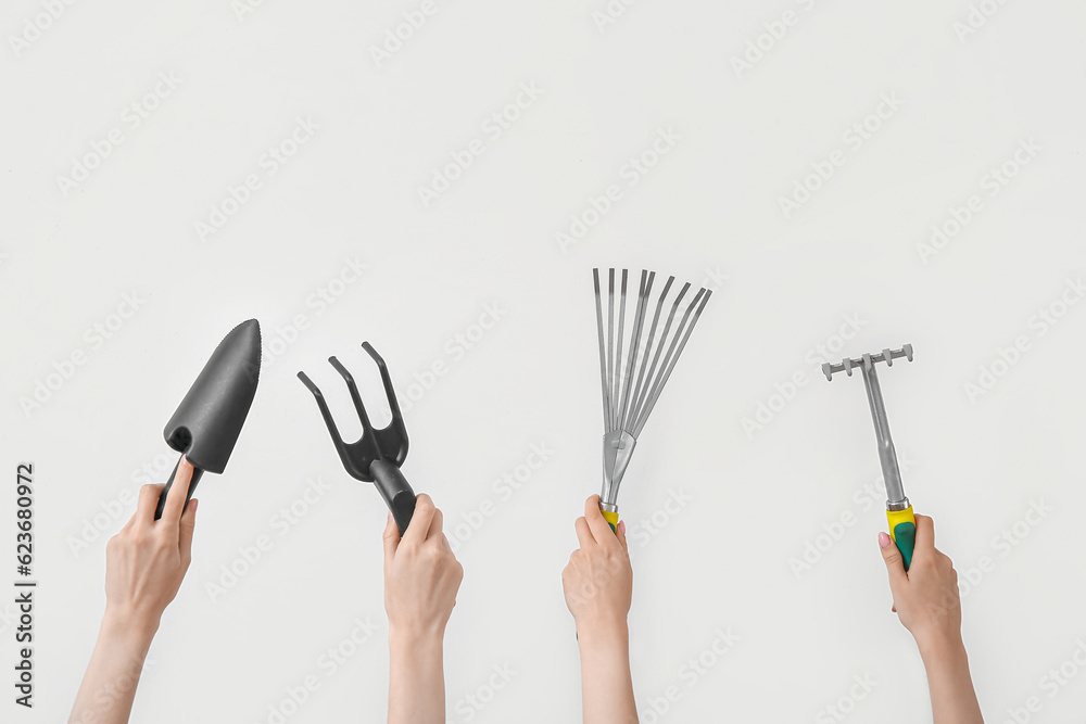 Women with different gardening tools on light background