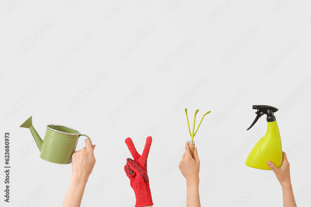 Women with different gardening tools on light background