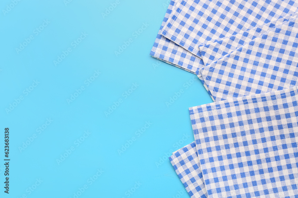 Set of checkered napkins on color background