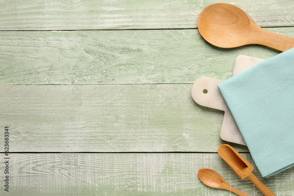 Composition with kitchen utensils and clean napkin on color wooden background