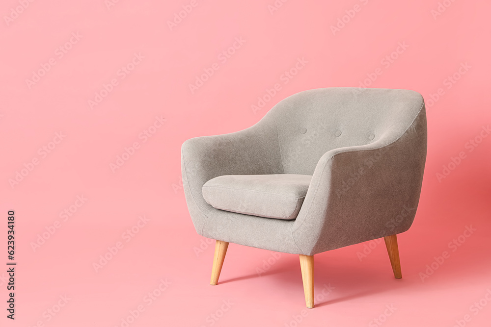 Grey armchair on pink background