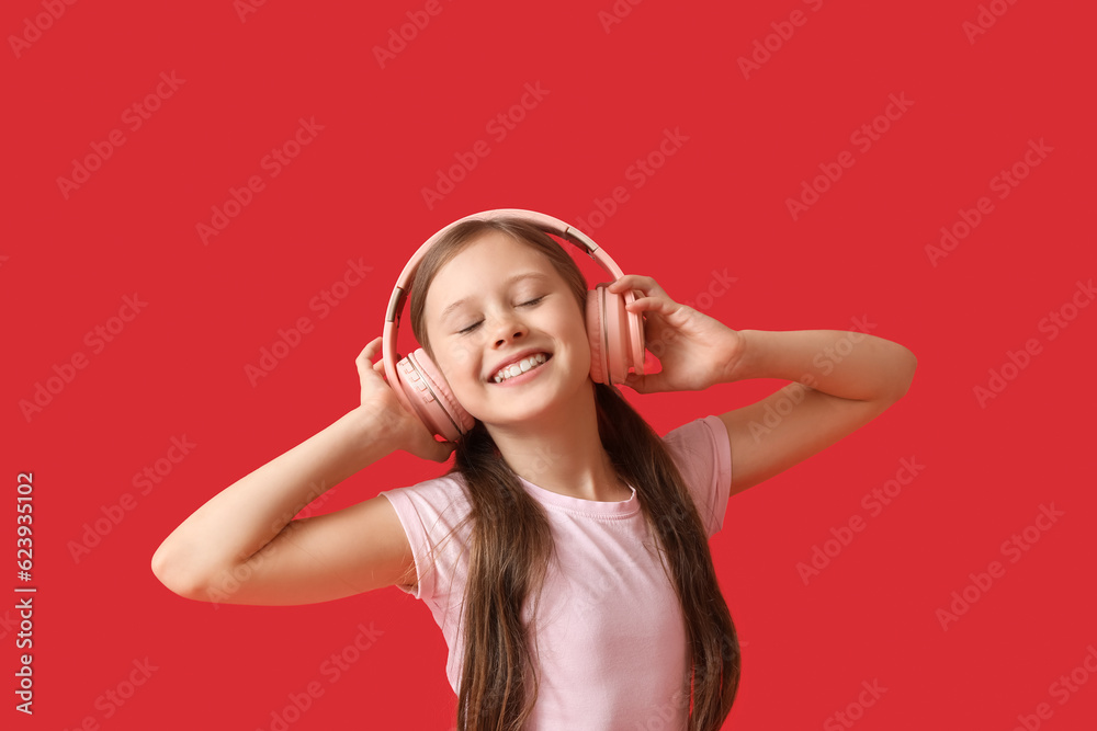 Little girl in headphones on red background