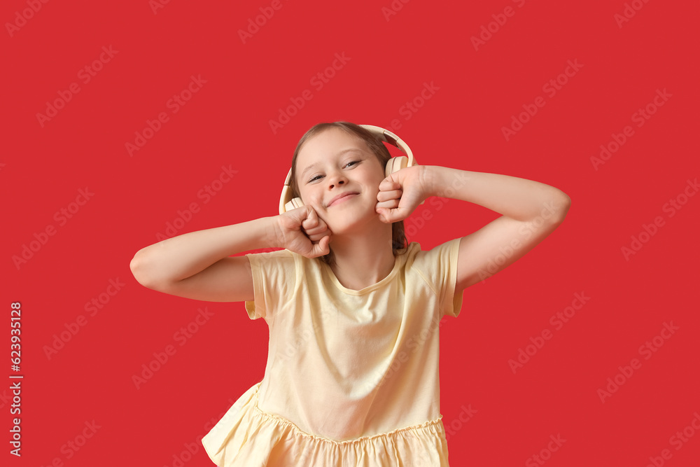 Little girl in headphones on red background