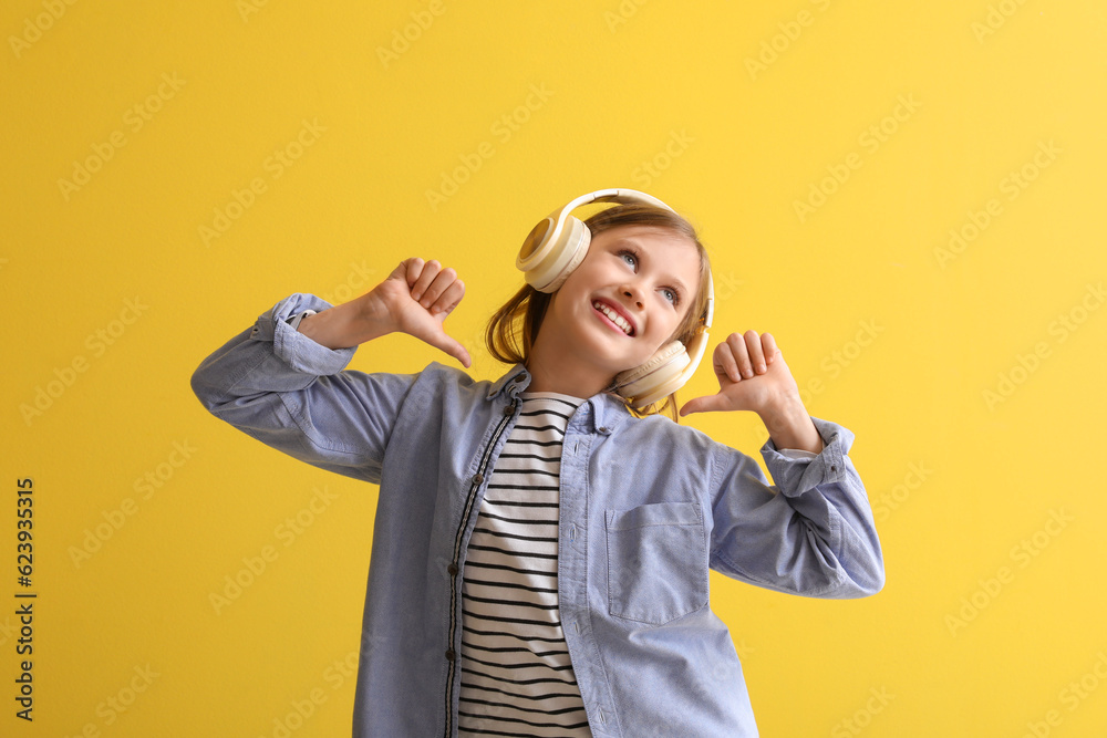 Little girl in headphones pointing at herself on yellow background