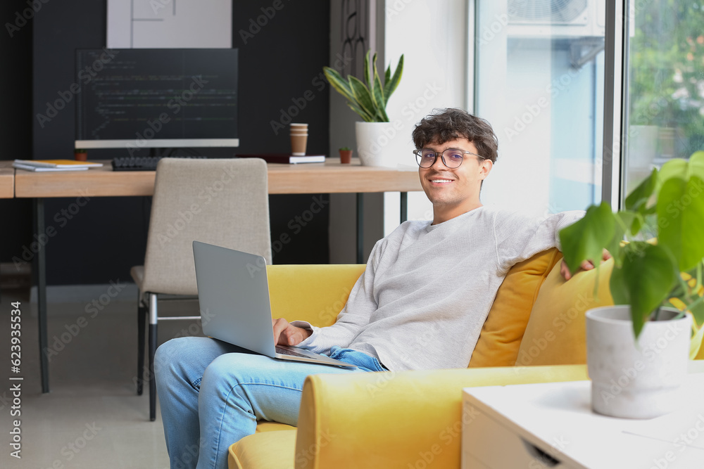 Male programmer working with laptop in office