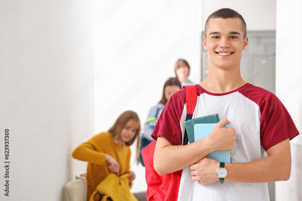 Teenage boy with books at school