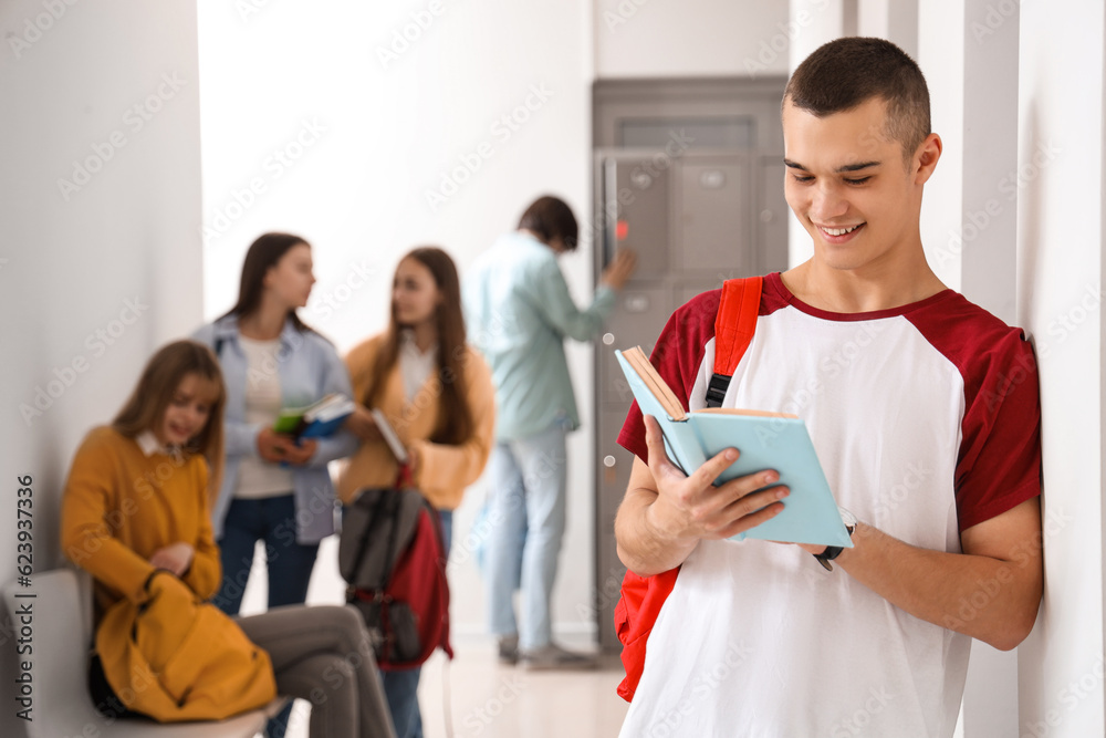 Teenage boy reading book at school