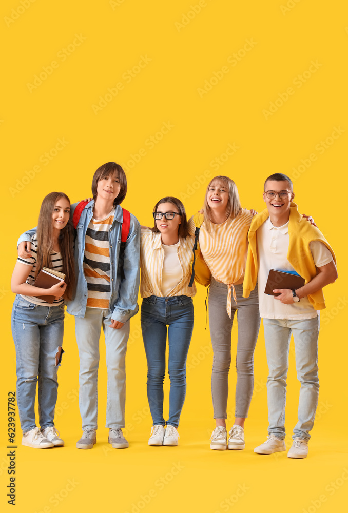 Group of teenage students on yellow background