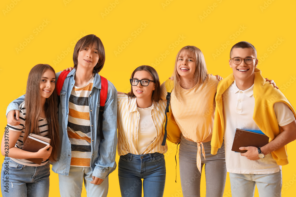 Group of teenage students on yellow background