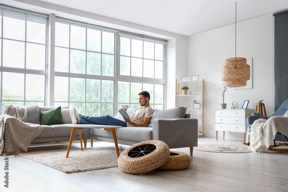 Young man reading book on his day off at home