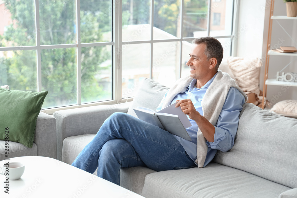 Mature man reading book on his day off at home